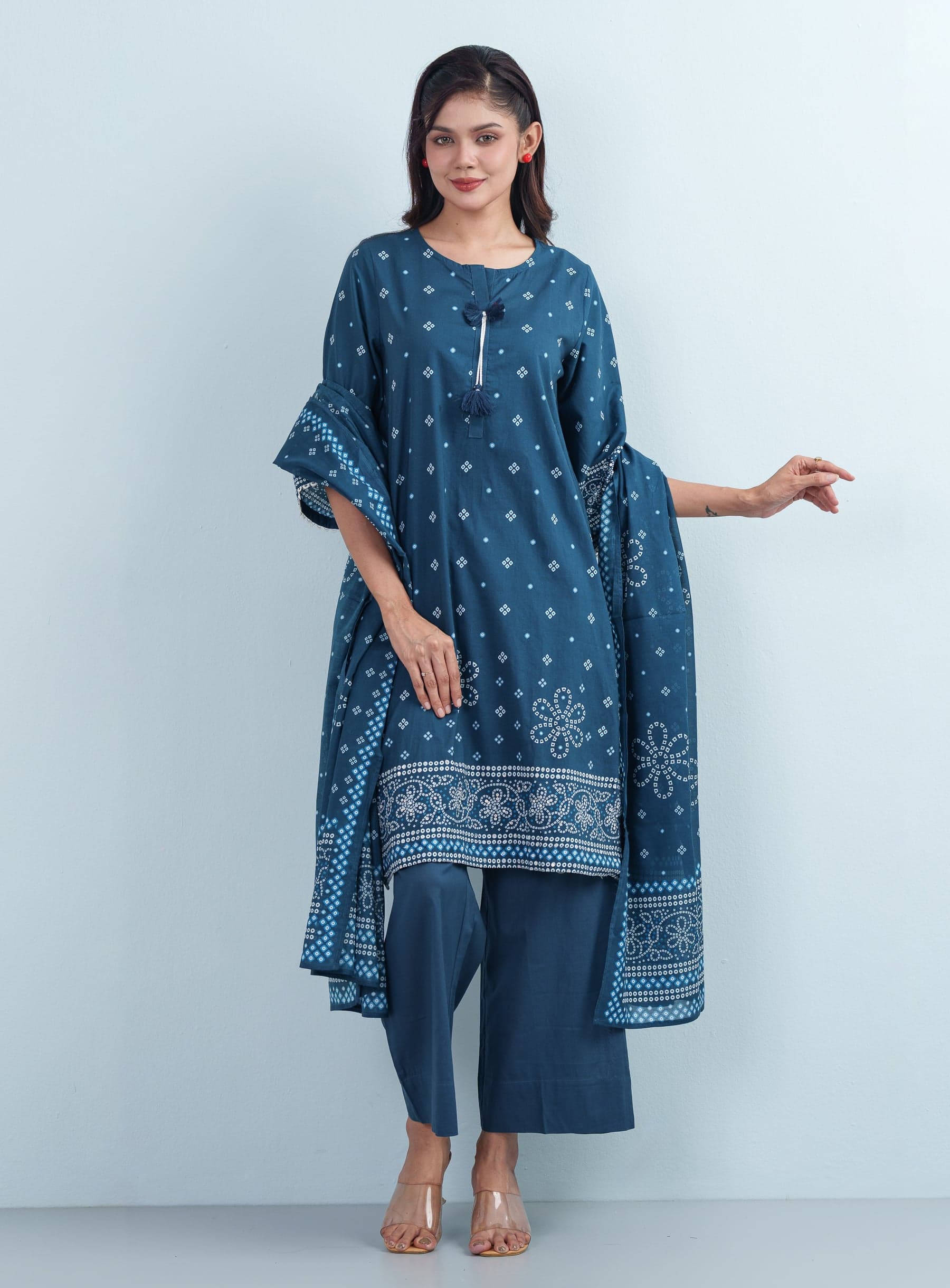 Full-length side angle shot displaying the matching printed dupatta draped elegantly over a women's three piece cotton suit.