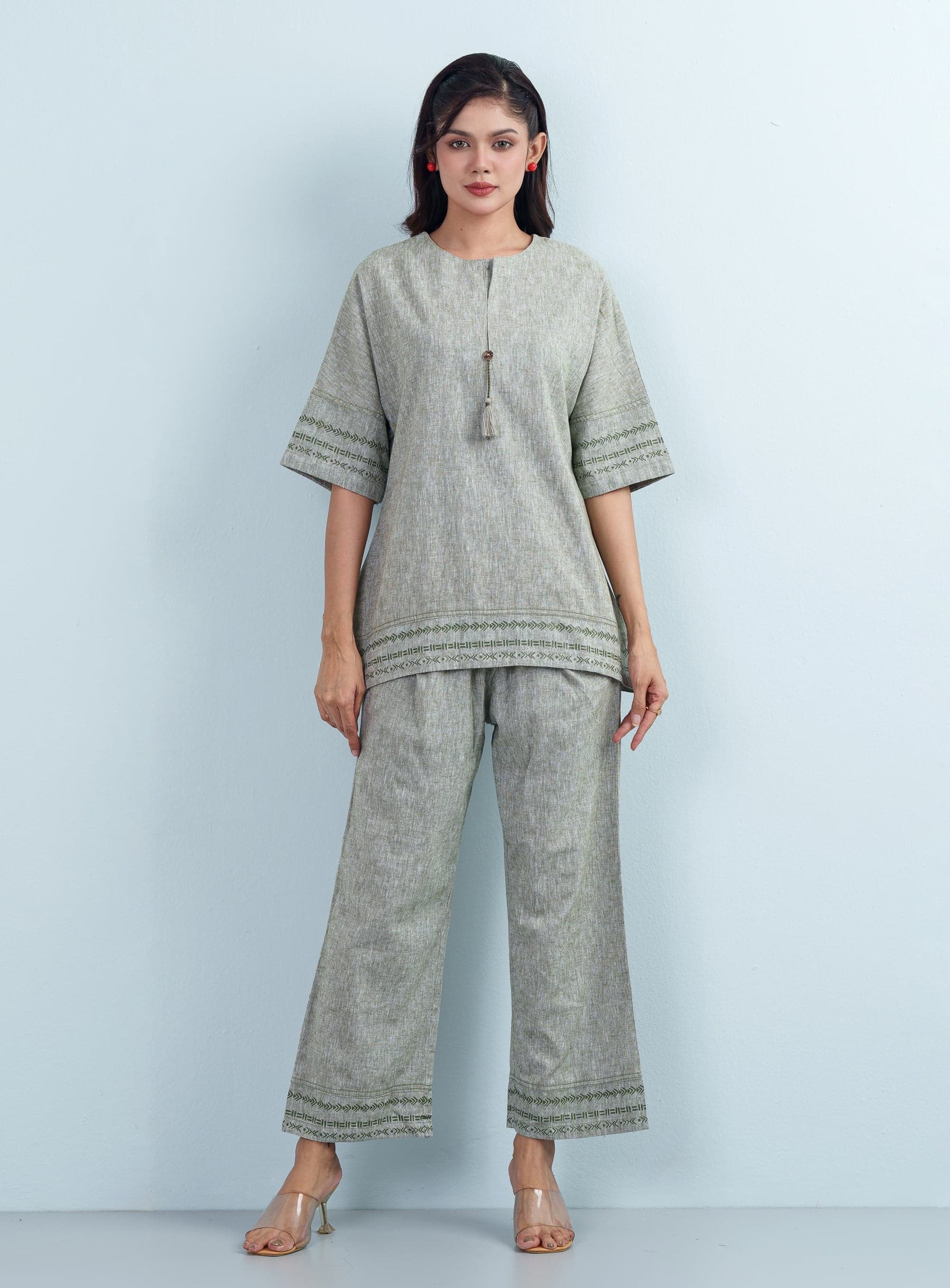Front view of a model standing in a comfortable loose-fit women's two piece matching tunic and wide trousers.