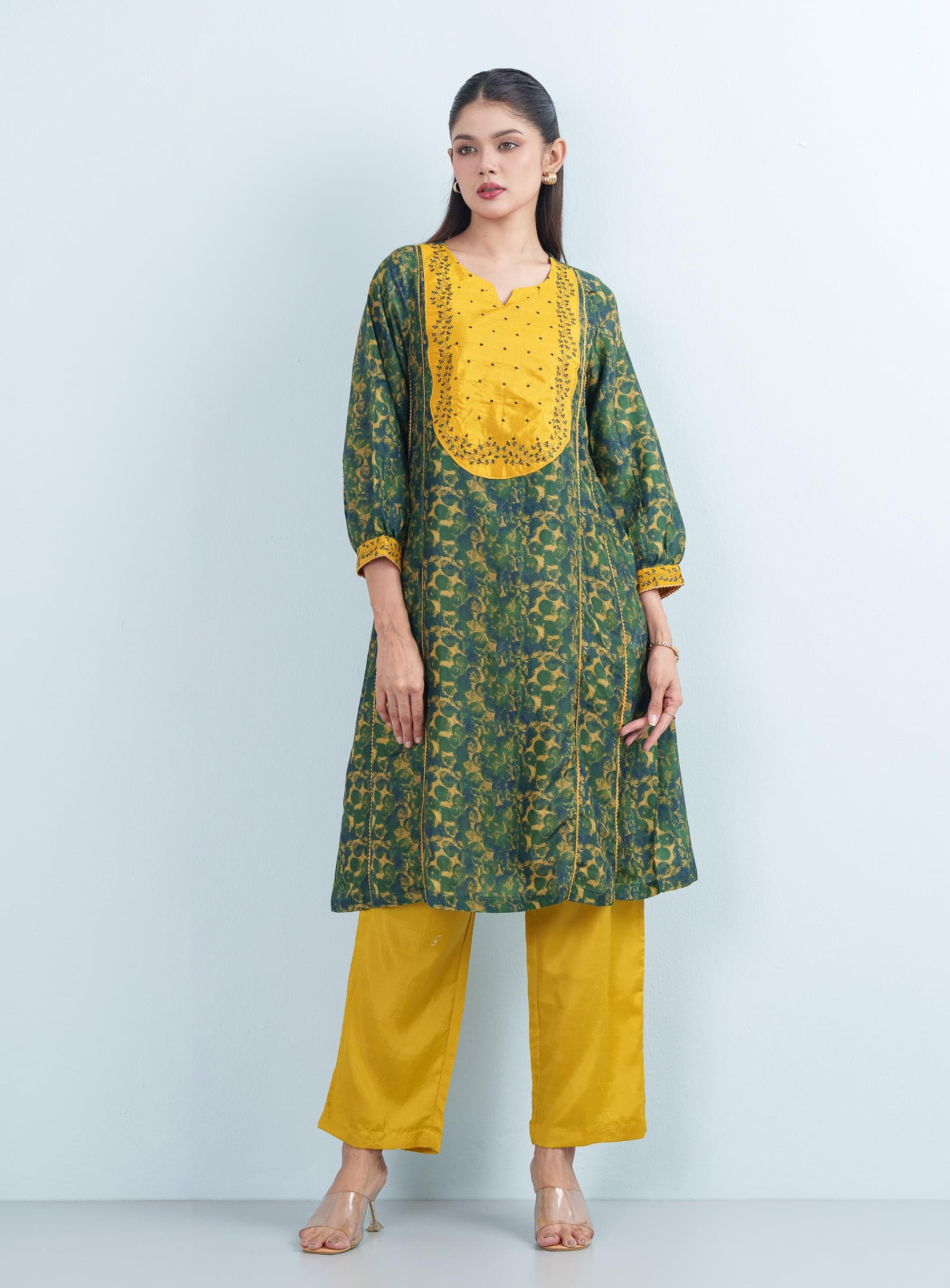 Front studio portrait of a woman modeling a breathable, relaxed-fit green and yellow women's two piece trouser suit.