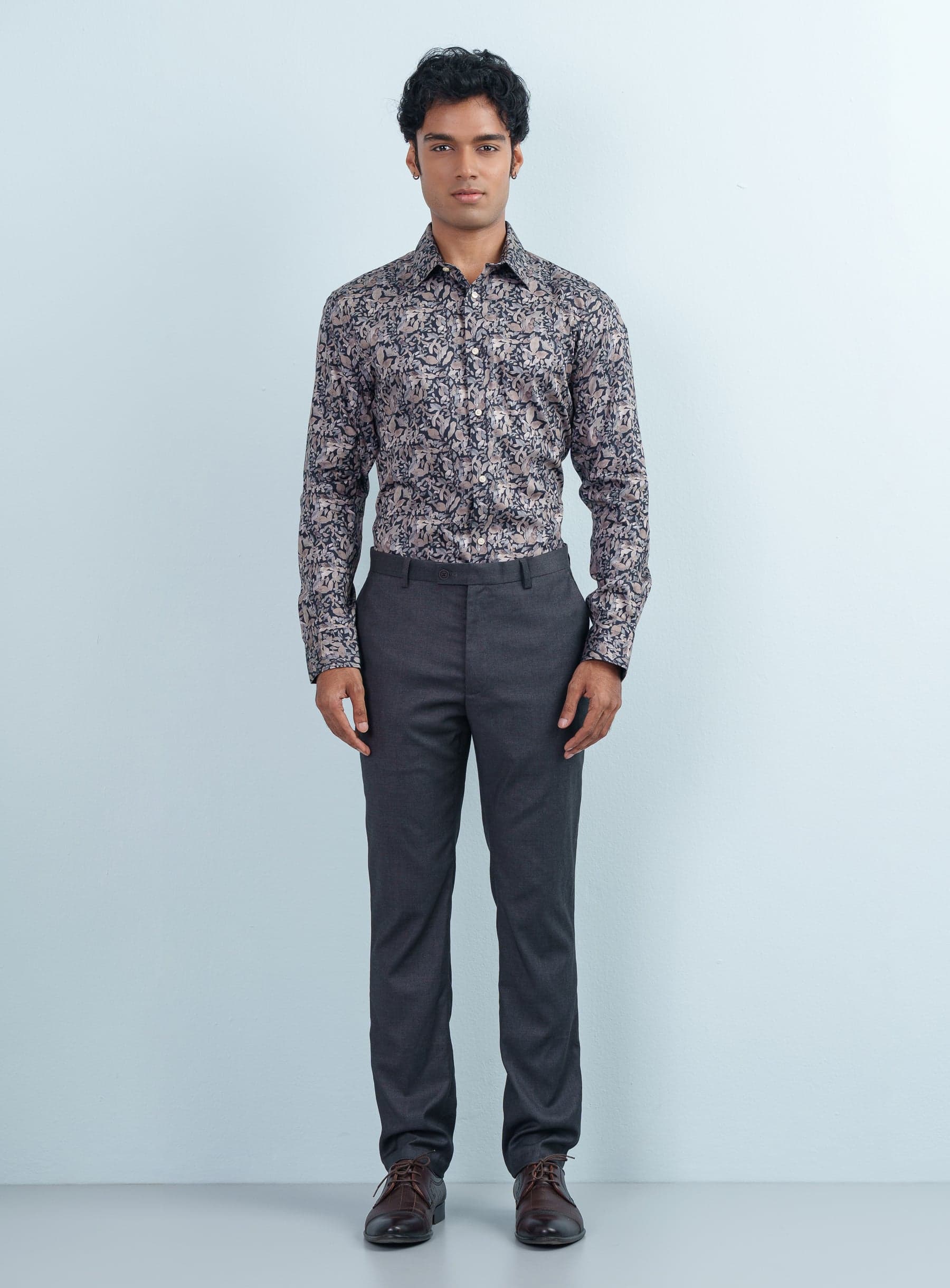 Front view of a man posing in a slim fit multi-color floral print formal shirt full sleeve with charcoal pants.