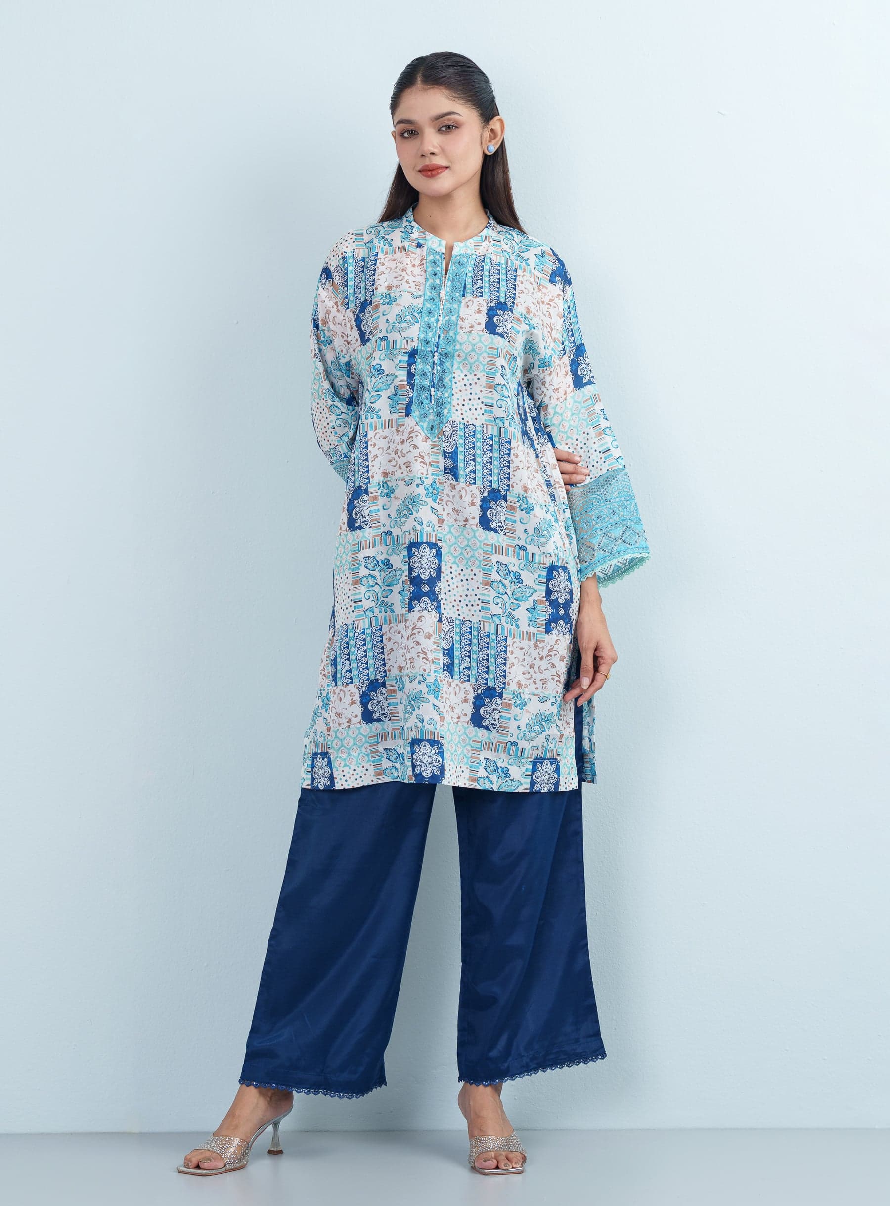 Full-length studio shot of a model presenting a blue and aqua geometric print women's two piece co-ord set.