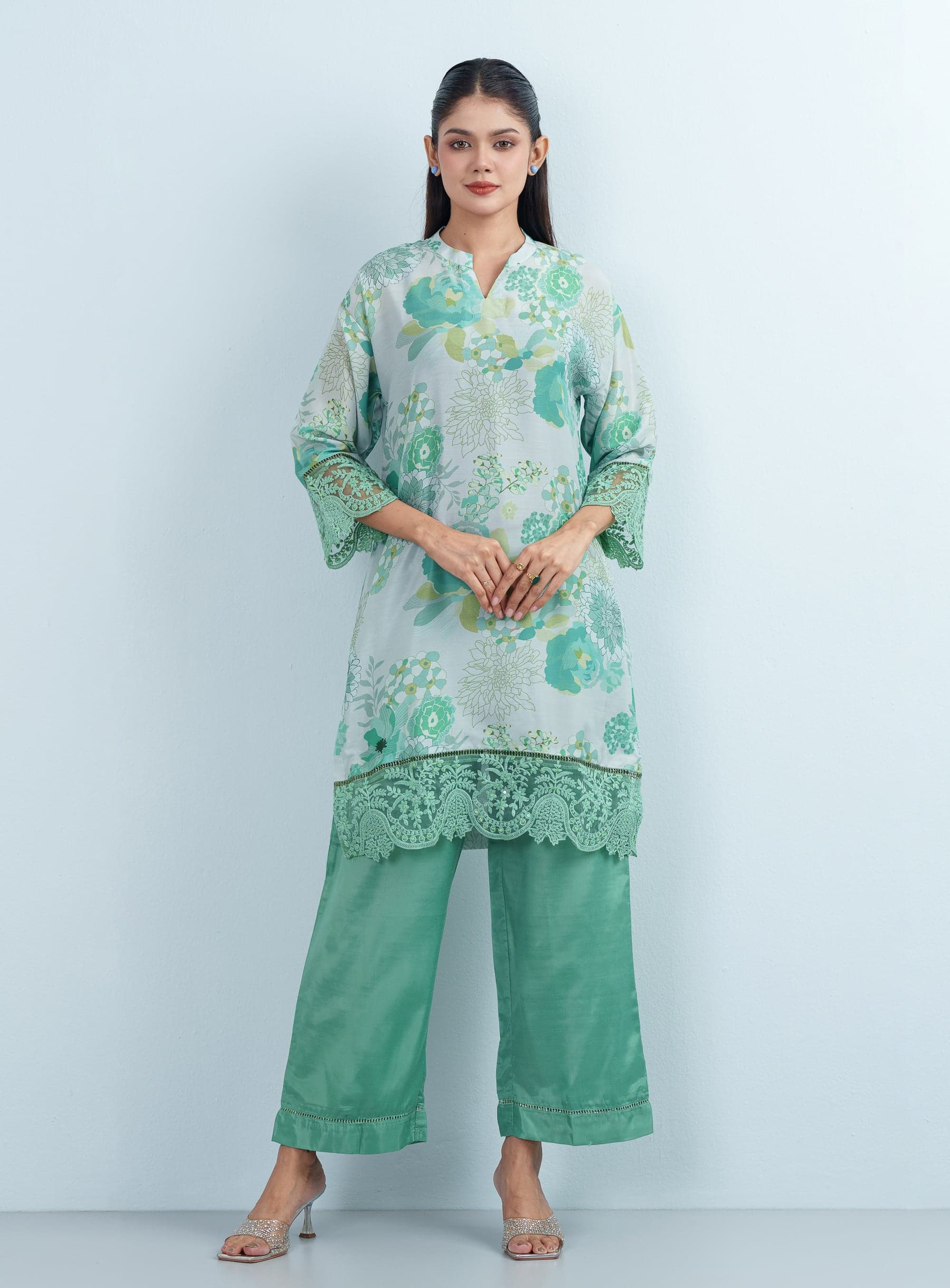 Full-length front shot of a model presenting a botanical print women's two piece co-ord set with scalloped lace details.