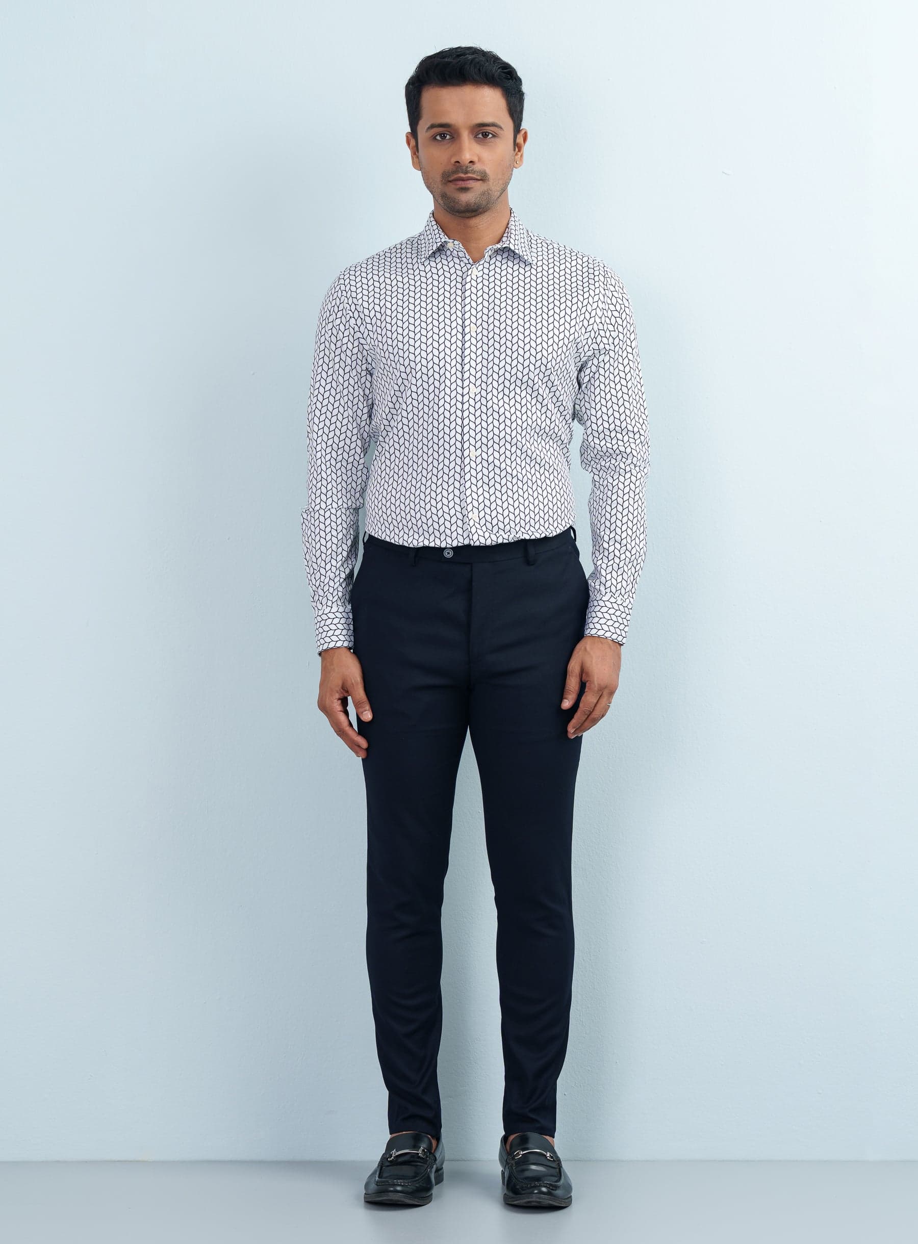 Front view portrait of a male model with hands clasped wearing a monochrome geometric wave print formal shirt